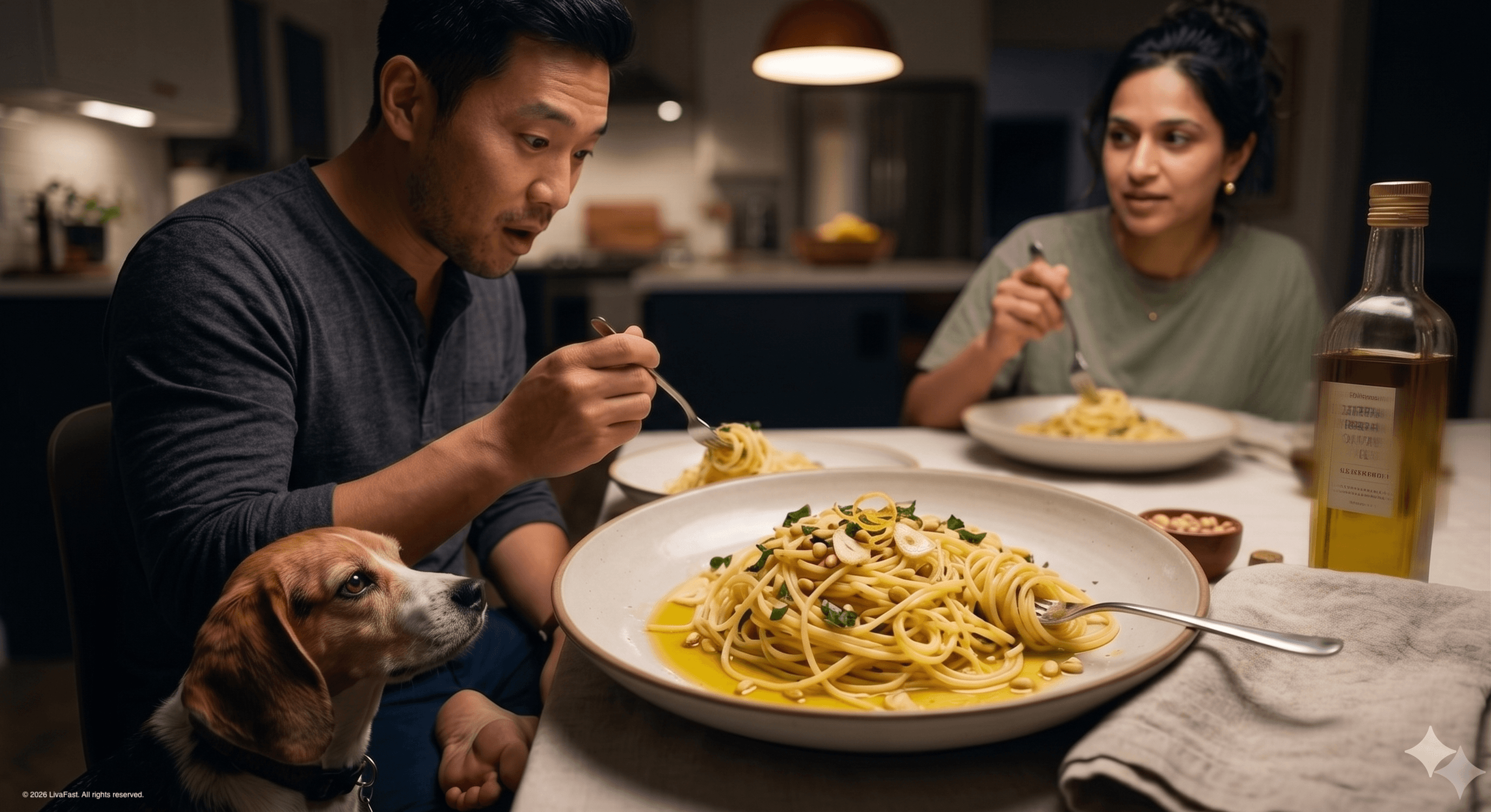 Mark at the kitchen table at 8 PM, eyes on his first forkful of olive-oil-and-lemon spaghetti scattered with basil and pine nuts, Biscuit the beagle locked on his fork from below.